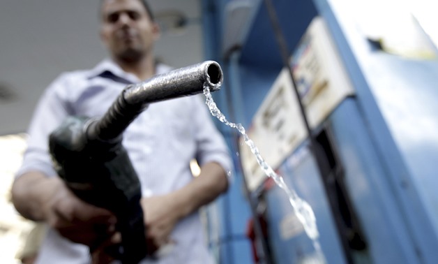 A worker holds up a fuel pump nozzle after filling up the tank of a car at a petrol station in Cairo October 3, 2012. REUTERS/Mohamed Abd El Ghany
