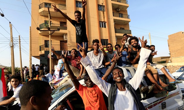FILE- Sudanese people chant slogans as they celebrate, after Sudan's ruling military council and a coalition of opposition and protest groups reached an agreement to share power during a transition period leading to elections, along the streets of Khartou