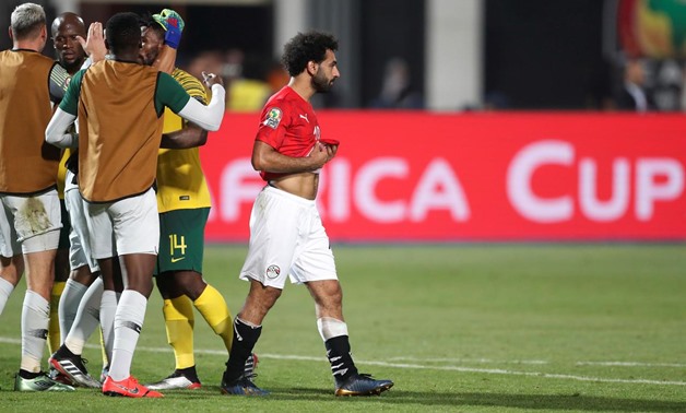 Soccer Football - Africa Cup of Nations 2019 - Round of 16 - Egypt v South Africa - Cairo International Stadium, Cairo, Egypt - July 6, 2019 Egypt's Mohamed Salah looks dejected after the match as South Africa players celebrate REUTERS/Amr Abdallah Dalsh