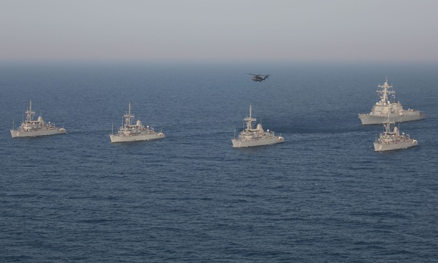 A formation of Avenger-class mine countermeasure ships USS Devastator (MCM 6), USS Gladiator (MCM 11), USS Sentry (MCM 3), USS Dextrous (MCM 13), the Arleigh Burke-class guided missile destroyer USS Mason (DDG 87) and an MH-53E Sea Dragon helicopter assig