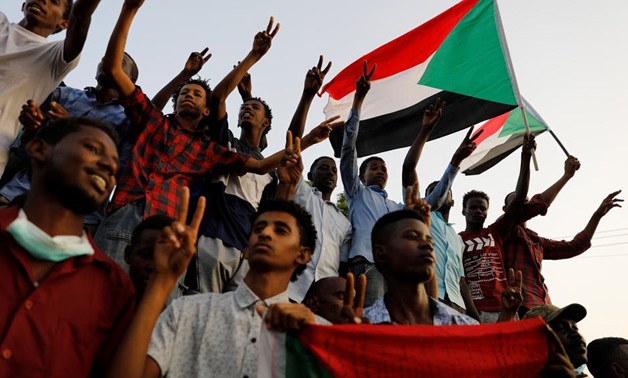Sudanese demonstrators make victory signs and wave Sudanese flags as they protest in front of the Defence Ministry in Khartoum, Sudan April 17, 2019. REUTERS/Umit Bektas
