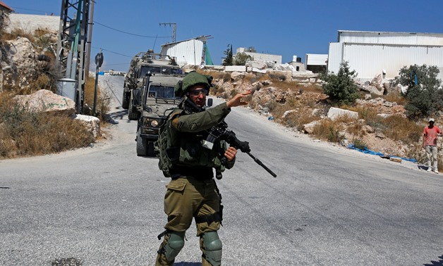 An Israeli soldier gestures during a raid after the Israeli military said an Israeli soldier was found stabbed to death near a Jewish settlement, in Beit Fajjar in the Israeli-occupied West Bank August 8, 2019. REUTERS/Mussa Qawasma