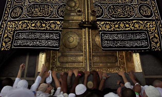 Muslims touch and pray at the door of the Kaaba in the holy city of Mecca, Saudi Arabia. January 22, 2016.  REUTERS/Amr Abdallah Dalsh