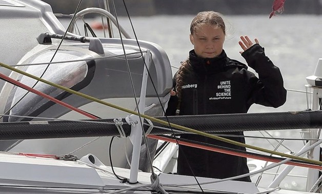 Swedish climate activist Greta Thunberg waves from aboard the Malizia II IMOCA class sailing yacht which is taking her to New York