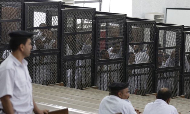 Islamist defendants stand behind bars in the case known as the "Kerdasa massacre'', that referred 188 people to court over an attack that killed 14 policemen in 2013, in Cairo June 23, 2014/REUTERS

