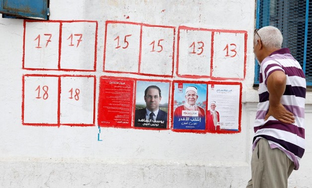 A man looks election posters of presidential candidates in Tunis, Tunisia September 2, 2019. REUTERS/Zoubeir Souissi
