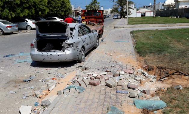 Workers remove a damaged civilian vehicle, after a missile hit the terminal's park of Mitiga airport in Tripoli, Libya August 24, 2019. REUTERS/Ismail Zitouny
