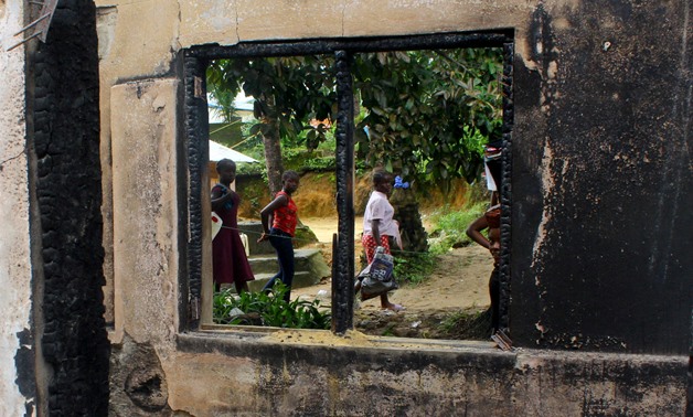People are seen through the charred window of a building after a fire swept through a school killing children in Monrovia, Liberia September 18, 2019. REUTERS/Stringer.
