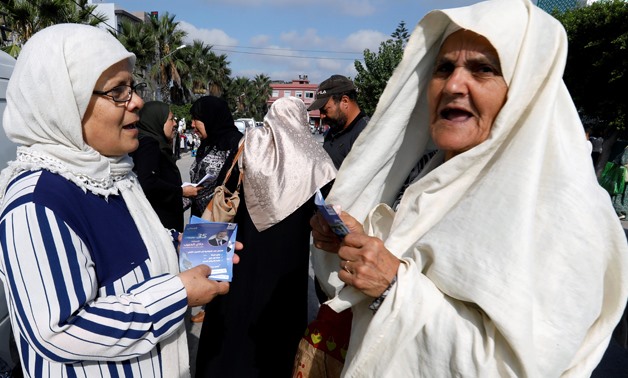 A supporter of Tunisia's moderate Islamist Ennahda party, talks with a woman while distributing election leaflets for the upcoming parliamentary elections in the hilltop town of al-Alia, Tunisia September 30, 2019. Picture taken September 30, 2019. REUTER