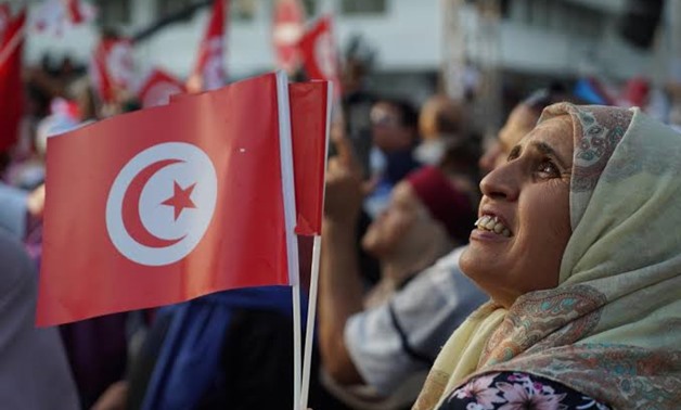 A woman raises the Tunisian flag