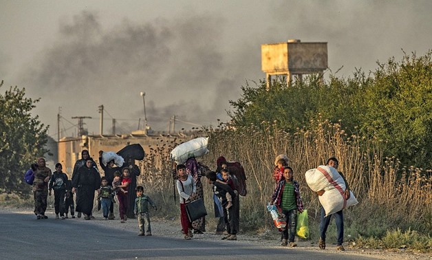 Syrian Arab and Kurdish civilians flee with their belongings amid Turkish bombardment on Syria's northeastern town of Ras al-Ain on October 9, 2019. (Delil SOULEIMAN / AFP)
