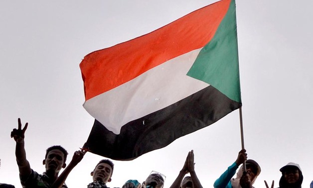 Sudanese demonstrators wave their national flag as they attend a protest rally demanding Sudanese President Omar Al-Bashir to step down, outside Defence Ministry in Khartoum, Sudan April 10, 2019. REUTERS/Stringer