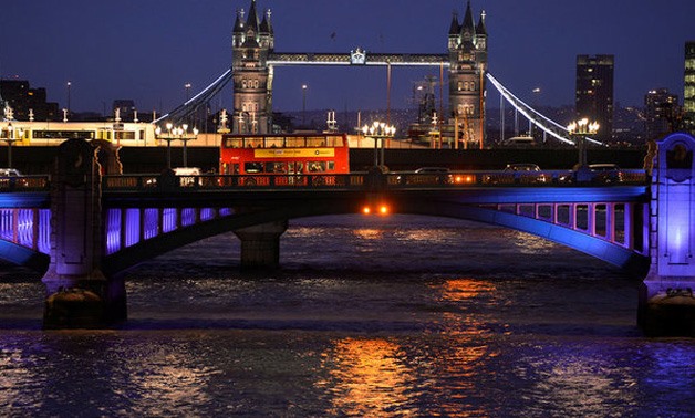 FILE PHOTO - A London bus crosses the River Thames on London Bridge during the evening rush hour with Tower Bridge seen behind in London December 18, 2013. REUTERS/Toby Melville/File Photo TPX IMAGES OF THE DAY