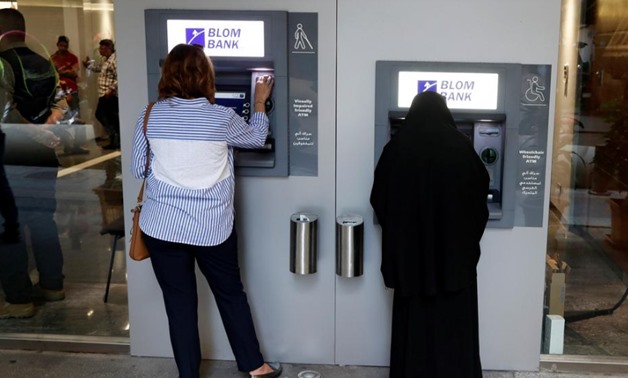 Women use ATMs at Blom bank in Beirut, Lebanon November 1, 2019. Picture taken through glass. REUTERS/Goran Tomasevic
