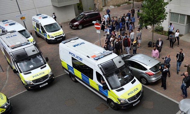 Police vans leave carrying a number of women who were detained after a block of flats was raided in Barking - REUTERS/Hannah McKay