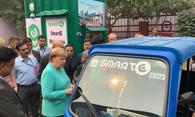 FILE PHOTO: German Chancellor Angela Merkel stands next to an electric vehicle during her visit to a solar powered metro station at Dwarka in New Delhi, India, November 2, 2019. REUTERS/Andreas Rinke
