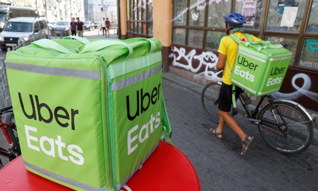 FILE PHOTO: An Uber Eats food delivery courier pulls a bicycle in central Kiev, Ukraine September 9, 2019. REUTERS/Valentyn Ogirenko
