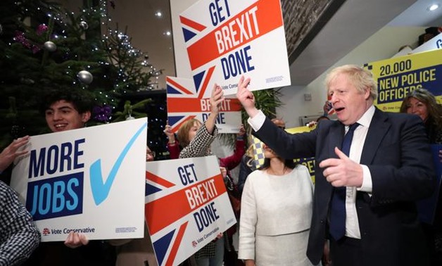 Britain's Prime Minister Boris Johnson holds a sign as he arrives to attend a rally event in Colchester, Britain December 2, 2019. REUTERS/Hannah McKay/Pool
