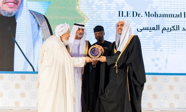 Sheikh Muhammad bin Abdul Karim Issa receiving the prize from Sheikh Abdullah bin Bayyah - press photo