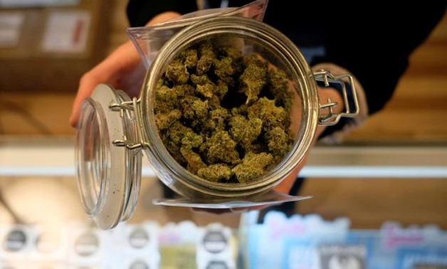FILE PHOTO: An employee holds a jar of marijuana on sale at the Greenstone Provisions after it became legal in the state to sell recreational marijuana to customers over 21 years old in Ann Arbor, Michigan, U.S., December 3, 2019. REUTERS/Matthew Hatcher/
