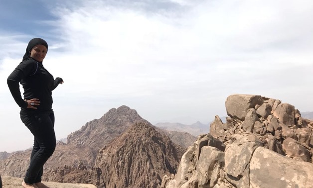 Mai Adel on the top of Rimhan Mountain, South Sinai, in March 2018. Adel likes to take a picture with bare feet at the top of every mountain she climbs to "feel the energy of the place" unless it is too cold. 