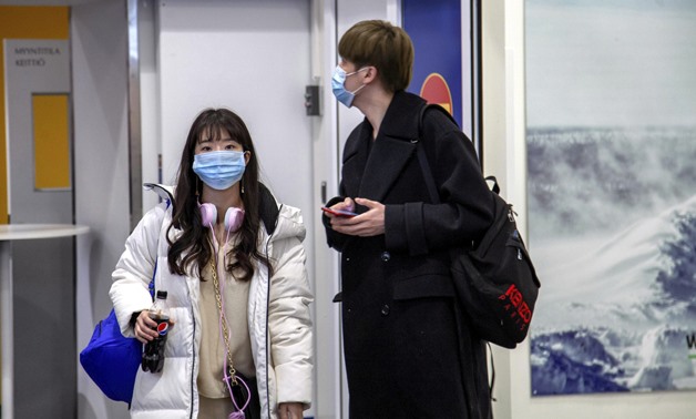 Air travellers wear masks as they arrive at Ivalo Airport, Finland January 24, 2020. On Thursday, two tourists visiting Finland from Wuhan, China went to a health centre in Ivalo, seeking treatment for flu-like symptoms. The tourists are suspected of bein