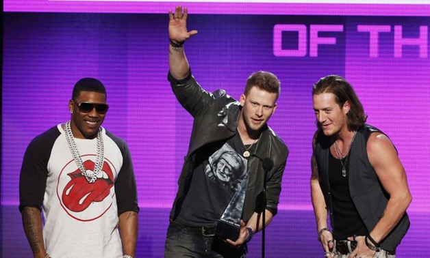 Hip hop artist Nelly with Brian Kelley and Tyler Hubbard (right) of Florida Georgia Line accept the single of the year award at the 41st American Music Awards in Los Angeles, California November 24, 2013. — Reuters