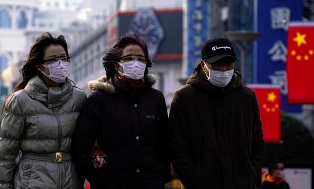 People wearing protective masks walk at the Nanjing Road in Shanghai, China January 29, 2020. REUTERS/Aly Song