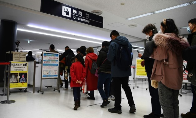 Passengers who arrived on one of the last flights from the Chinese city of Wuhan walk through a health screening station at Narita airport in Chiba prefecture, outside Tokyo
Japan's health authorities confirmed a second case on Friday. Local media said t