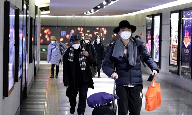 FILE PHOTO: People wearing masks walk through an underground passage to the subway in Beijing, China January 21, 2020. REUTERS/Jason Lee/File Photo
