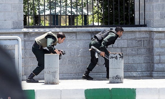 Members of Iranian forces take cover during an attack on the Iranian parliament in central Tehran, Iran, June 7, 2017.