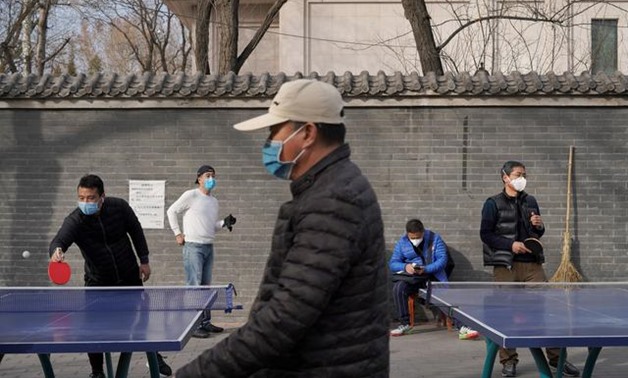 People wearing face masks play table tennis at a park, following an outbreak of the novel coronavirus in the country, in Beijing, China February 21, 2020. REUTERS/Stringer
