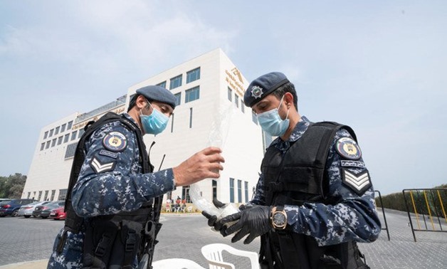 FILE - Kuwaiti police wearing masks after several people were infected with coronavirus in Kuwait - Reuters