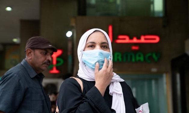 FILE PHOTO: A woman wears a protective face mask, following the outbreak of the new coronavirus, in Kuwait, February 25, 2020. REUTERS/Stephanie McGehee/File Photo
