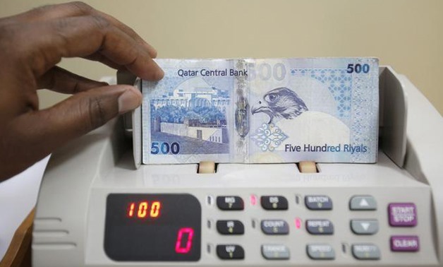 A cashier counts Qatari riyal notes at a money changer -  REUTERS/Fadi Al-Assaad