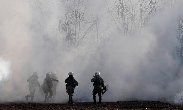 Greek riot police officers walk amid clouds of tear gas near Turkey's Pazarkule border crossing, in Kastanies, Greece March 6, 2020. REUTERS/Florion Goga
