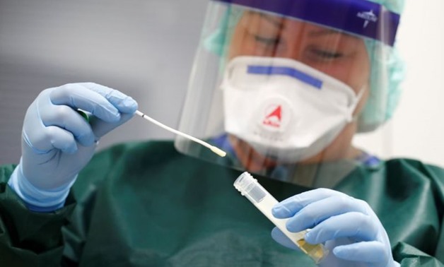 FILE PHOTO: Canan Emcan, 31, chief nurse of the infection and virologist ward of the university clinic of Essen closes a sample of a smear test to be used in case of coronavirus patients during a media event in Essen, Germany, March 5, 2020. REUTERS/Wolfg