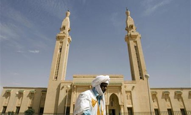 Mauritanian old man walking past a mosque - Reuters