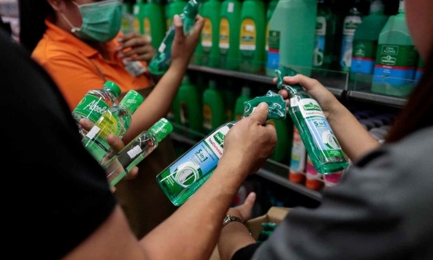 FILE - People hold bottles of alcohol sterilizers in Philippines - Reuters
