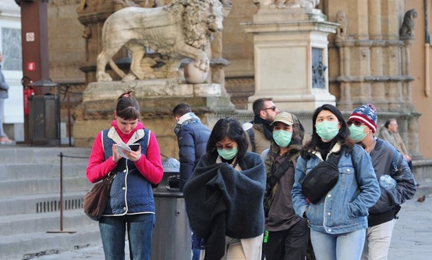 People wearing protective masks walk through Florence as Italy battles a coronavirus outbreak, in Florence, Italy, March 7, 2020. REUTERS/Jennifer Lorenzini
