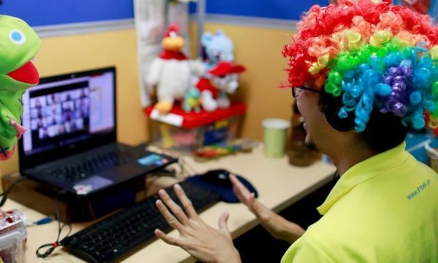A Filipino online tutor wears a wig as he talks to students from a computer in the head office of 51Talk, as the spread of the coronavirus disease (COVID-19) continues, in Pasig City, Metro Manila, Philippines March 12, 2020. REUTERS/Eloisa Lopez