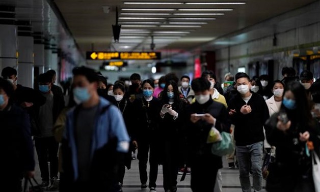 passengers wearing face masks are seen at a subway station after the city's emergency alert level for coronavirus disease (COVID-19) was downgraded, in Shanghai, China March 23, 2020. REUTERS/Aly Song