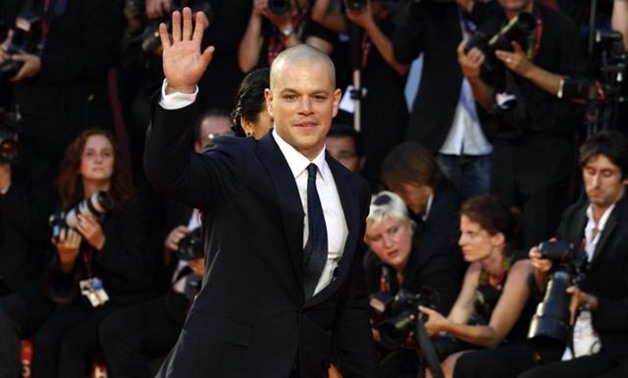 FILE PHOTO: Actor Matt Damon (R), cast member of the movie "Contagion", waves as he arrives on the red carpet at Cinema Palace during the 68th Venice Film Festival September 3, 2011. REUTERS/Alessandro Bianchi.