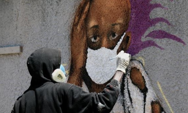Serigne Boye, AKA Zeus, a graffiti artist part of the RBS crew works on his mural to encourage people to protect themselves amid the outbreak of the coronavirus in Dakar Senegal on March 25, 2020 - Reuters/Zohra Bensemra
