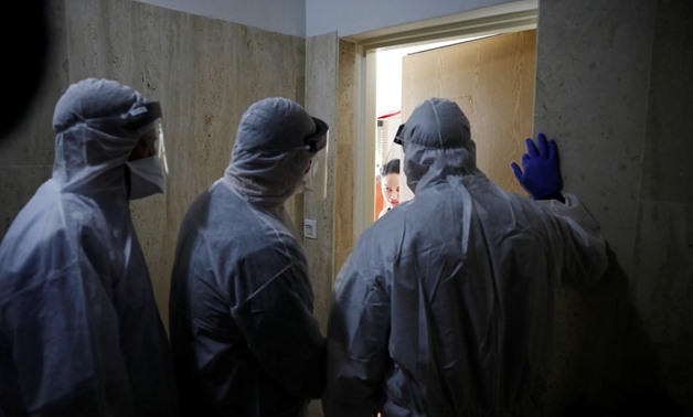 Health Ministry inspectors speak with a woman who is in self quarantine as a precaution against coronavirus spread in Hadera, Israel March 16, 2020 REUTERS/Ronen Zvulun
