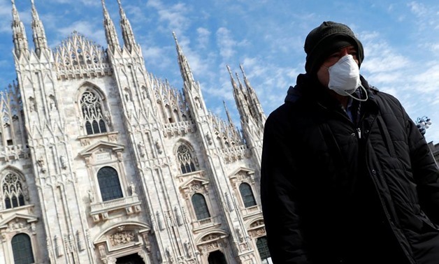 A man wearing a protective face mask to prevent contracting the coronavirus walks past the Duomo Cathedral in Milan, Italy, March 4, 2020. REUTERS/Guglielmo Mangiapane
