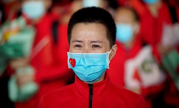A member of a medical team weeps at the Wuhan Tianhe International Airport after travel restrictions to leave Wuhan, the capital of Hubei province and China's epicentre of the novel coronavirus disease (COVID-19) outbreak, were lifted, April 8, 2020. REUT
