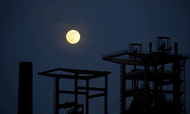 FILE PHOTO: The pink supermoon rises behind the ruin of a blast furnace of the former Phoenix West steel mill in Dortmund, Germany, April 7, 2020. REUTERS/Leon Kuegeler
