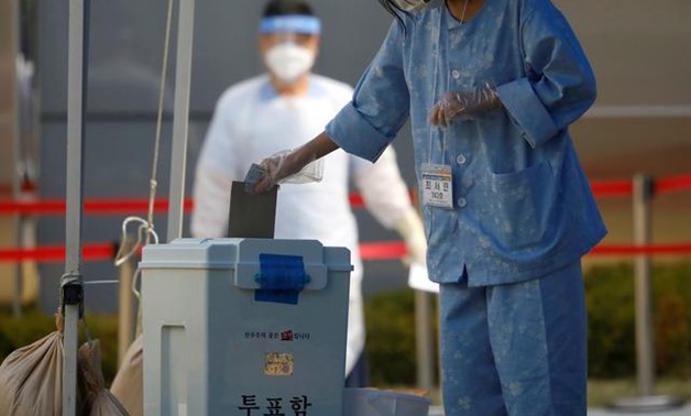 FILE PHOTO: A South Korean patient affected with the coronavirus disease (COVID-19) casts her ballot for the parliamentary election at a polling station set up at a quarantine center in Yongin, South Korea, April 11, 2020. REUTERS/Kim Hong-Ji/File Photo
