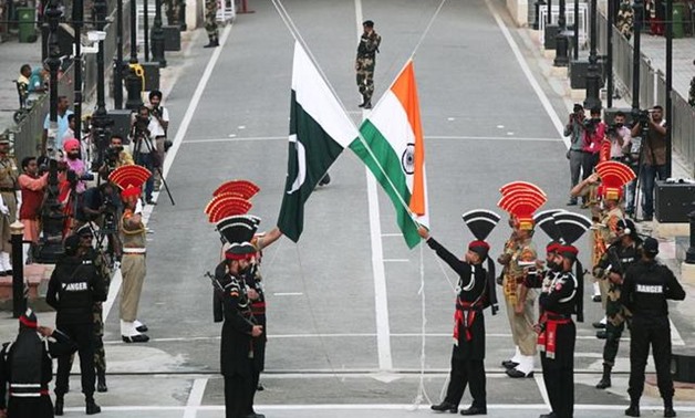 FILE PHOTO: Pakistani Rangers (wearing black uniforms) and Indian Border Security Force (BSF) officers lower their national flags during parade on the Pakistan's 72nd Independence Day, at the Pakistan-India joint check-post at Wagah border, near Lahore, P
